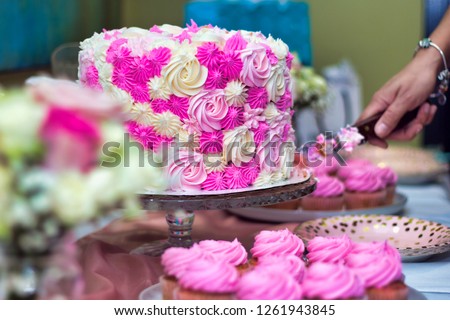 Sweet sixteen pink and white cake being cut before being served