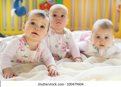 Sweet Small Triplets Lying In Nursery Room