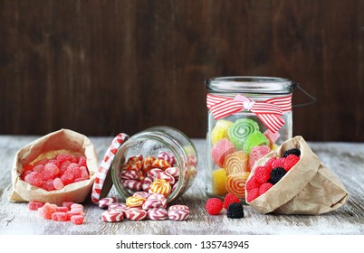 Sweet Sugar Candies In Glass Jars On Brown Vintage Wooden Background