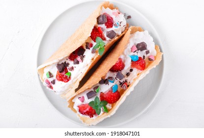 Sweet Tacos With Thin Waffle, Cottage Cheese Cream And Strawberry Topped With Chocolate And Mint On The White Ceramic Plate. Dessert Variation Of Mexican Classics