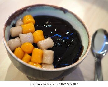 sweet Taiwanese dessert with toppings, grass jelly and taro ball  on wooden table (Chaokuay)