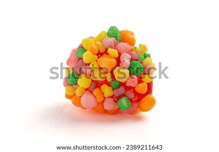 A Sweet and Tangy Candy with Small Candies on the Outside of a Chewy Center on a White Background