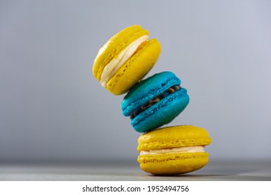 Sweet, tasty and colorful - blue and yellow french macarons on a light background, one on top of the other, a pyramid. The dessert is sweet. Selective focus. Sweet concept
