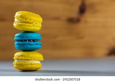 Sweet, tasty and colorful - blue and yellow french macarons on a light background, one on top of the other, a pyramid. The dessert is sweet. Selective focus. Sweet concept 