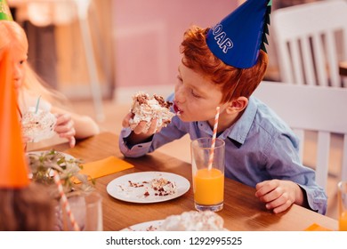 Sweet Teeth. Busy Kid Wearing Paper Hat While Visiting Birthday Party