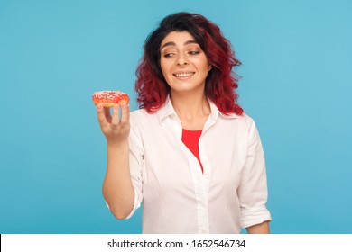 Sweet Temptation. Portrait Of Hungry Pretty Woman Looking At Appetizing Donut With Desire, Craving To Bite Delicious Pastry, High-calorie Junk Food. Indoor Studio Shot Isolated On Blue Background