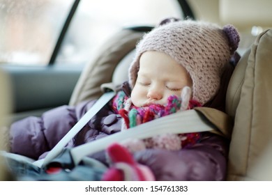 Sweet Toddler Girl Sleeping Peacefully In A Car Seat At Winter