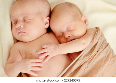 sweet twins are sleeping and hugging in soft focus