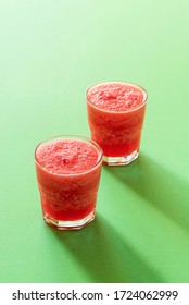 Sweet Watermelon Slush On A Green Background In Harsh Light. Two Glasses Of Watermelon Iced Drink. Summer Mocktail. Refreshing Beverage.