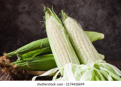 sweet white corn cobs on wooden table