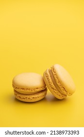Sweet yellow macarons. Traditional french macaroons. Tasty dessert on yellow background. - Shutterstock ID 2138973393