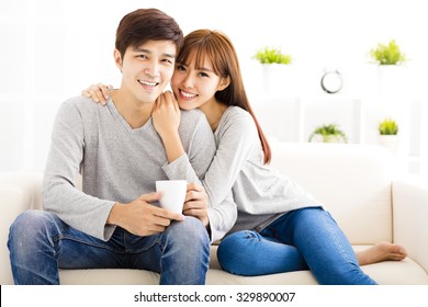 Sweet Young Couple Sitting In Sofa