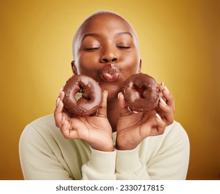 Sweets, smile and black woman with donuts, funny and happiness with expression, crazy or silly. Female person, dessert or goofy model with facial, chocolate or sugar against a brown studio background - Powered by Shutterstock