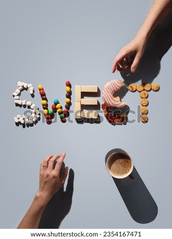 Sweets typography: waffles, marshmallows, cookies, marmalade, donut, candies. Hands reach for sweets. Food typography. Blue background. View from above