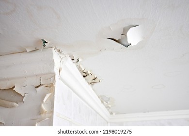 Swelling leaking of whitewash and plaster on ceiling of dwelling due to penetration of water from the top floor or roof, selective focus.