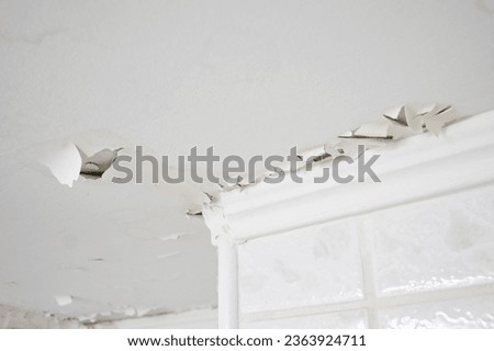 Swelling leaking of whitewash and plaster on ceiling of dwelling due to penetration of water from the top floor or roof, selective focus.
