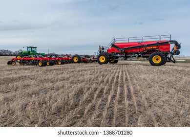 Swift Current, SK/Canada- May 4, 2019: Farmer With Tractor And Air Drill Seeding Equipment In A Field In Saskatchewan, Canada