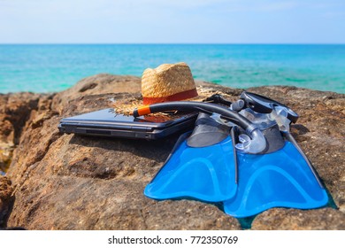 Swim Flippers, Mask, Snorkel,hat,laptop On  Rock Sea Beach And Blue Sky