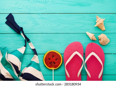 Swim Suit And Flip Flops On Blue Wooden Background