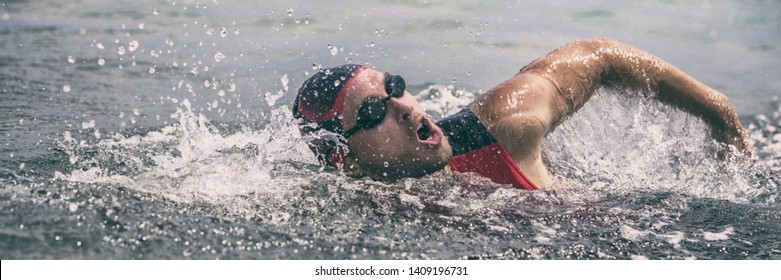 Swim triathlete man swimming freestyle crawl in ocean panorama banner. Male triathlon swimmer swimming in professional triathlon suit training for ironman on Hawaii. - Powered by Shutterstock