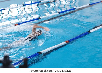 Swimmer in action at an indoor pool, with copy space. The image captures the dynamic movement and competitive spirit of the sport. - Powered by Shutterstock