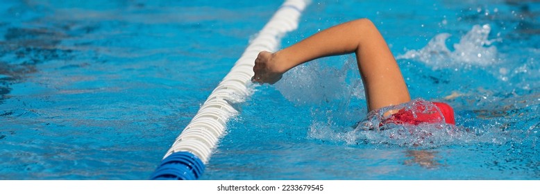 Swimmer child athlete swimming in pool lanes doing a crawl lap. Sport activities for children - Shutterstock ID 2233679545