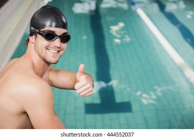 Swimmer gesturing thumbs up by the pool at leisure center - Powered by Shutterstock