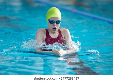 Swimmer girl swims breaststroke swimming style in the pool - Powered by Shutterstock