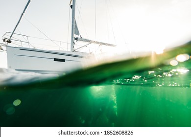 Swimmer Jumps From A Sailing Boat And Dives Into The Ocean Photographed Half Underwater