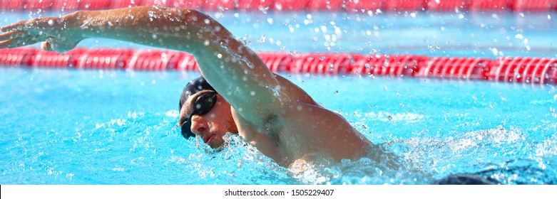 Swimmer Man Athlete Swimming In Pool Lanes Doing A Lap. Swim Race In Crawl. Banner Panorama Crop.