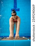 Swimmer posing for camera before backstroke start drill in water