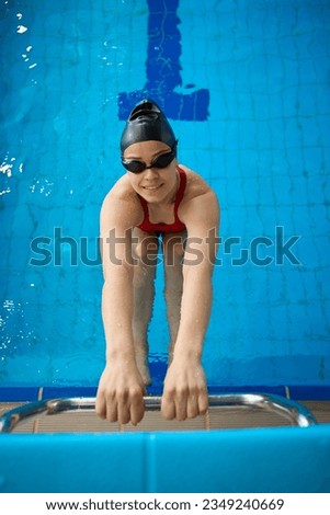 Swimmer posing for camera before backstroke start drill in water