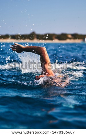 Swimmer training on the open sea / ocean.