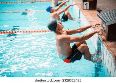 Swimmers poised at starting block in pool - Powered by Shutterstock