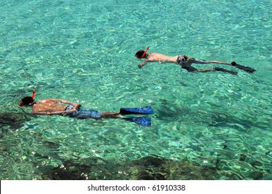 Swimmers Snorkeling In Crystal Clear Waters Of The Bahamas