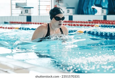 Swimming, athlete and sports woman in water for training, action and performance in competition, race and challenge. Pool, swimmer and underwater goggles for fitness, triathlon contest and exercise - Powered by Shutterstock