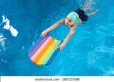 Swimming Class. Close Up Of Kids Practicing Flutter Kick With Kick Board In Swimming Pool