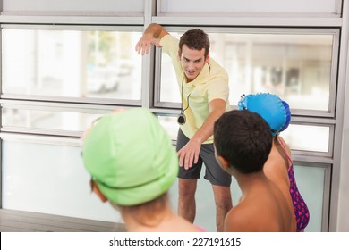 Swimming coach with his students poolside at the leisure center - Powered by Shutterstock