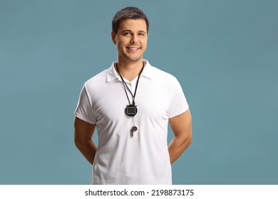 Swimming coach with a wistle and stopwatch around his neck isolated on blue background - Powered by Shutterstock