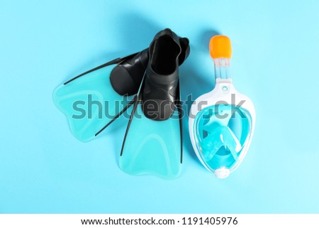 Swimming flippers and mask on color background, top view