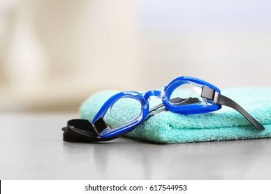 Swimming Goggles With Towel On Table