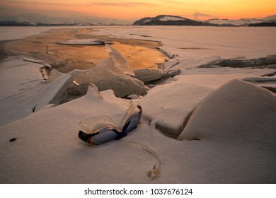 Swimming Googles And Colorful Sunset Over Frozen Lake Liptovska Mara, Slovakia