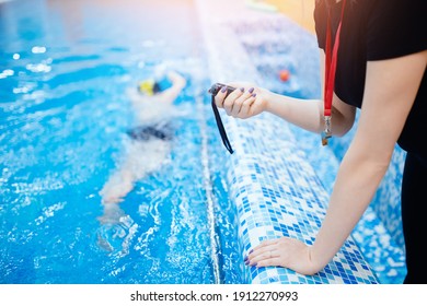 Swimming instructor coach people, woman hold in hand stopwatch during competitions in pool. - Powered by Shutterstock