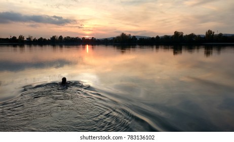 swimming in a lake in sunset