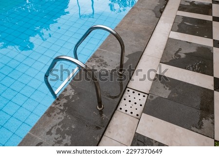 Swimming pool banister in an empty swimming pool, pool ladder