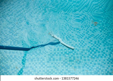 A Swimming Pool Being Cleaned With Pool Brush. Pool Floor And Tiles With Blue Water