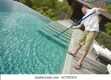 Swimming Pool Cleaner During His Work At Tropical Villa. Professional Cleaning Service At Work. Private Property Service.