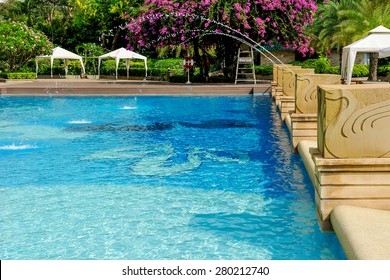 Swimming Pool Decorated With A Fountain.