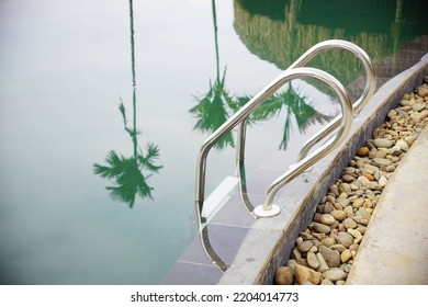 Swimming Pool Handrail Of A Mountain Resort With Palm Tree Reflection