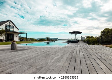 Swimming Pool And Hardwood Floor In Front Of Nursing Home Against Cloudy Sky. Unaltered, Retirement Home, Water, Tranquility And Nature Concept.